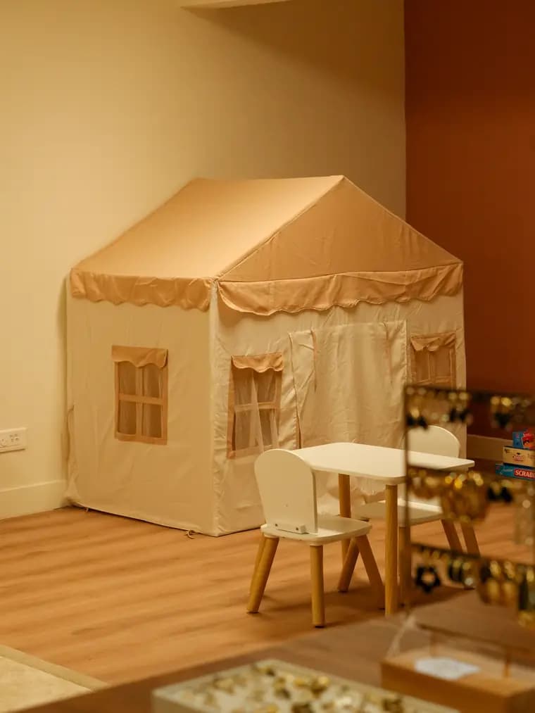 Le coin enfant : une cabane, une petite table, des jouets