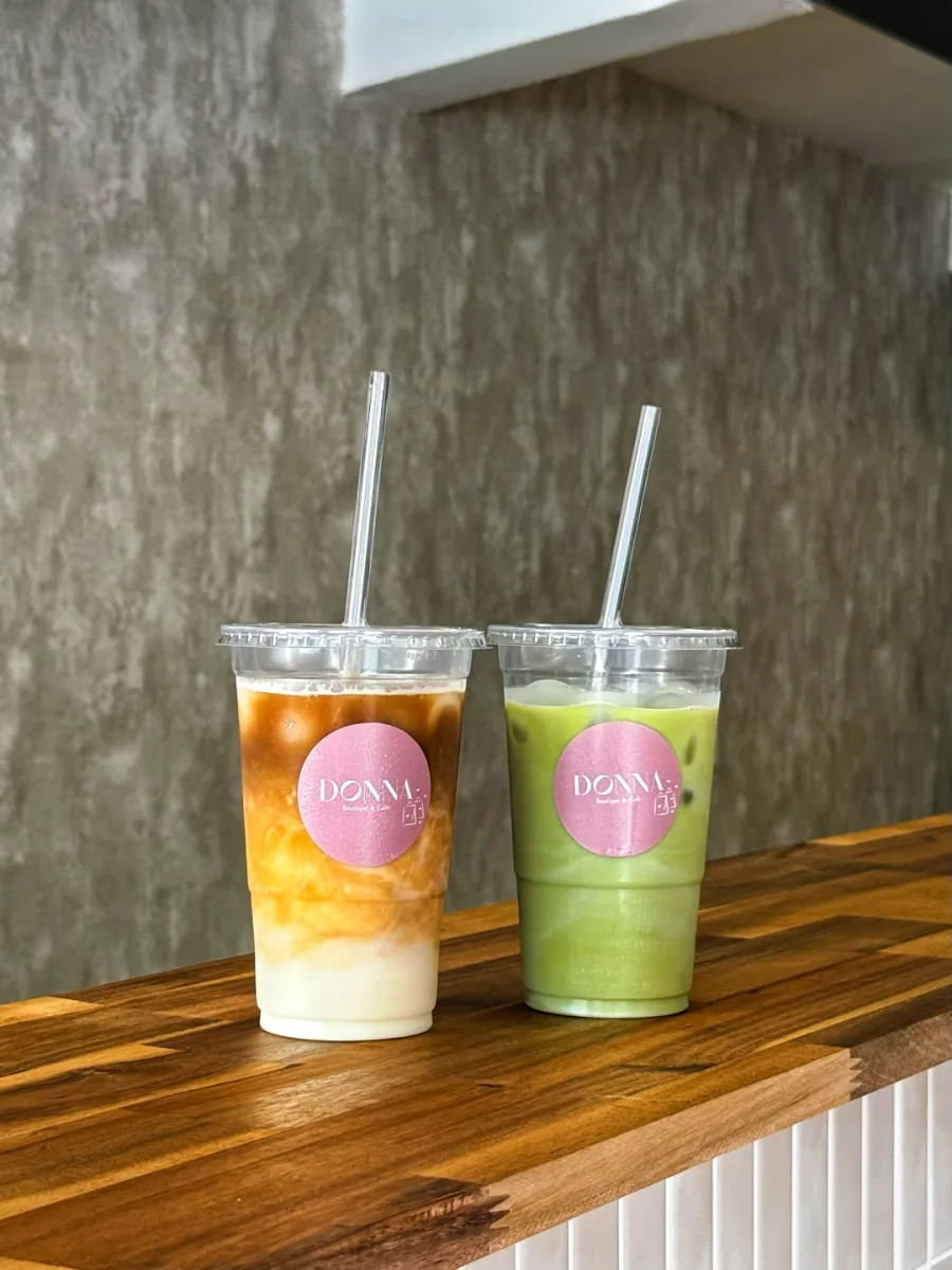 Un latte glacé et un matcha glacé aux étiquettes Donna, posés sur le comptoir en bois