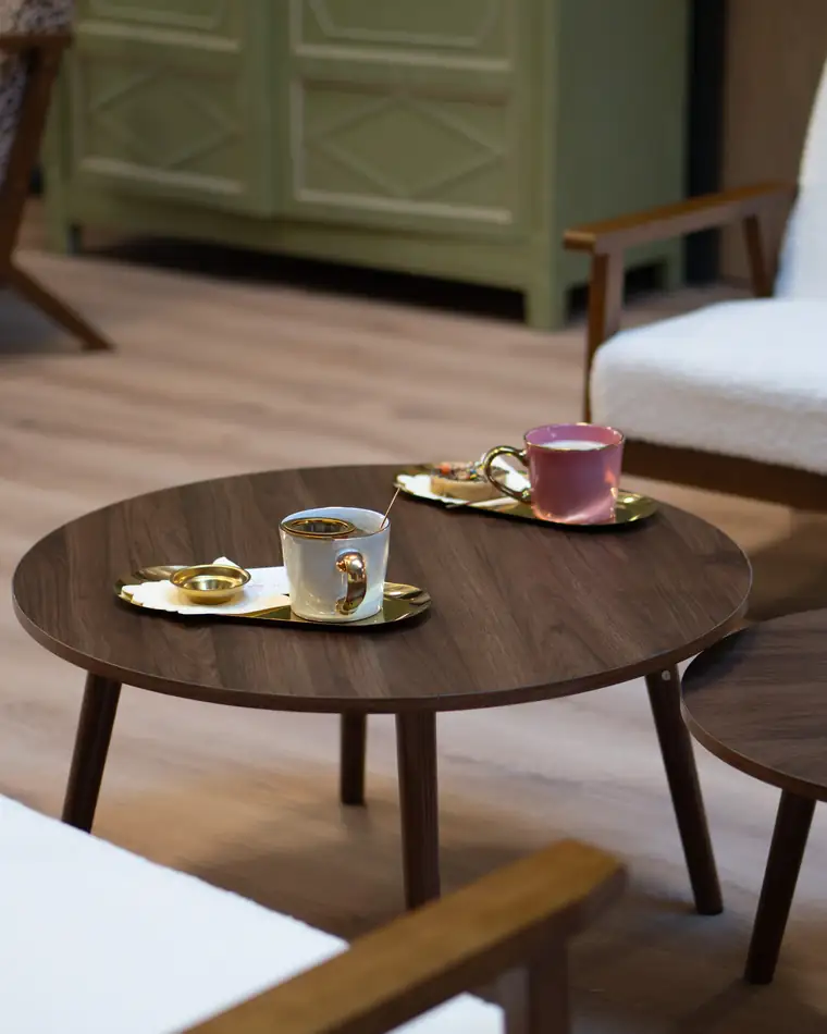 La pause au café : deux tasses sur une table ronde, devant les fauteuils